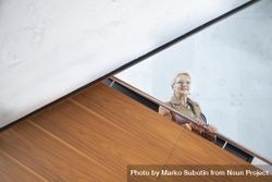 Mature woman in glasses looking down from stairs 47ER60