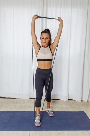 Athletic woman doing an arm workout using resistant rubber bands