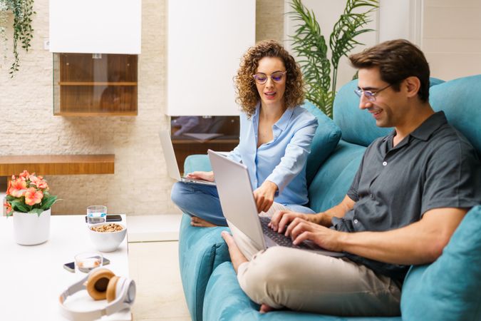 Couple working together from home in living room