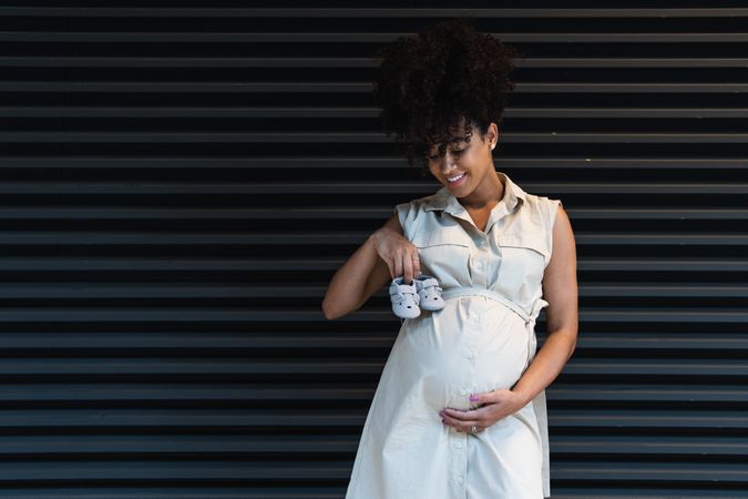 Smiling Black woman showing baby booties