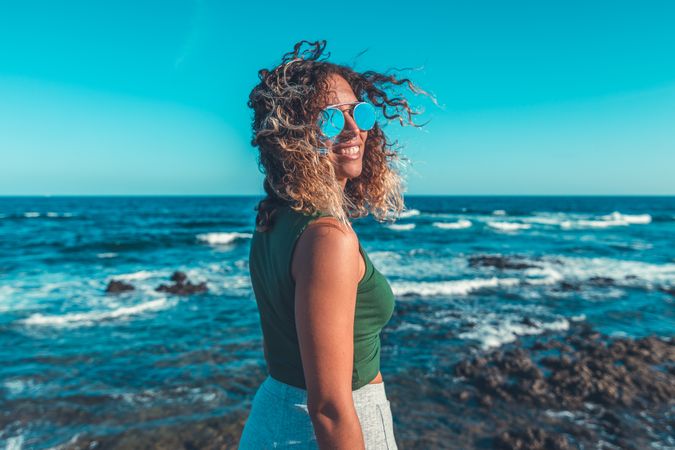 Stylish woman standing near sea
