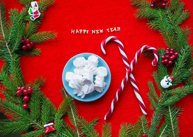 Christmas tree and candy on a red background with the words Happy New Year