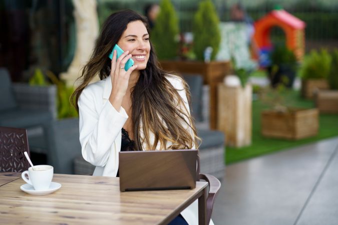 A Joyful Woman Engaged in a Chat on Her Phone While Working Outdoors Enjoying Nature