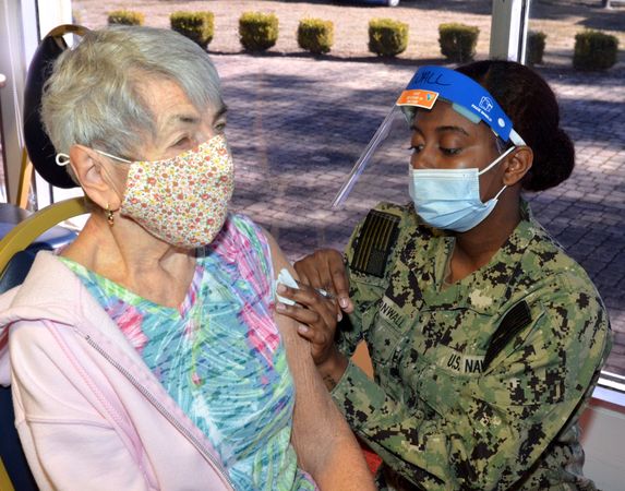 Jacksonville, FL - USA, Jan 15, 2021: A military nurse gives a mature patient a vaccine
