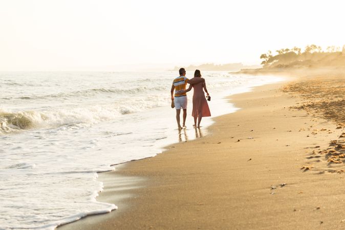 Adult couple walking towards sea