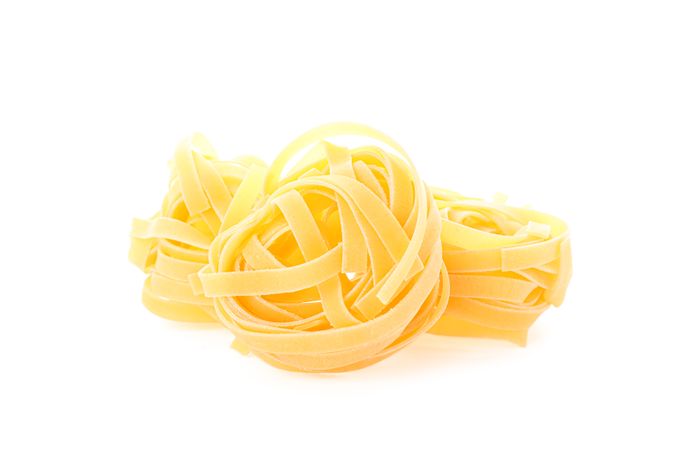 Pasta isolated on light background, closeup. Dry uncooked whole pasta