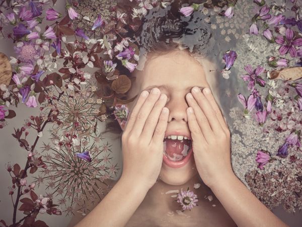 Boy screaming in bath with flowers