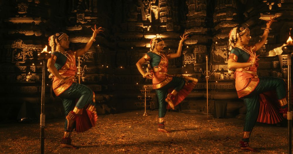 Portrait of an Active Female Indian Dancer Adorned in Traditional Costume Outside an Ancient Temple.