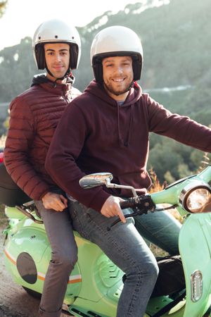 Two men in motorcycle looking at camera
