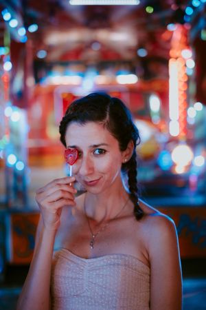 Woman with lollipop in amusement park