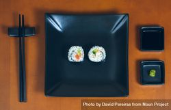 Top view of two freshly made sushi rolls on rectangular plate on table, ready to eat bG8el0