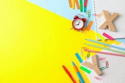 Flat lay composition with school supplies on two tone background, space for text