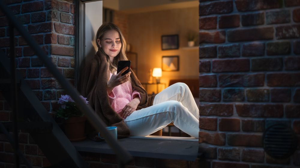 Young Female Smiling While Browsing Through Potential Matches in an Online Dating App