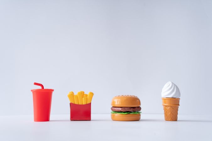 Plastic fast food items on light background