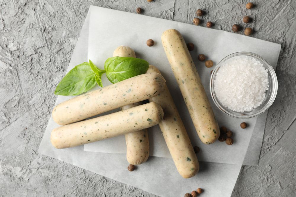 Top view of light colored German sausages on parchment paper