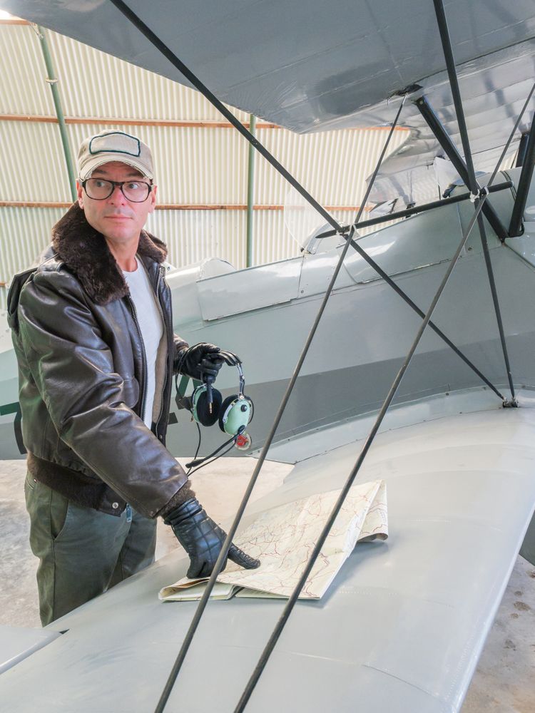 Pilot with map beside small plane