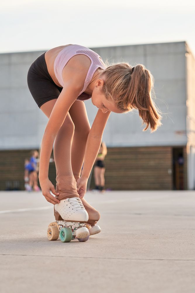 Sportive girl preparing for roller skating training