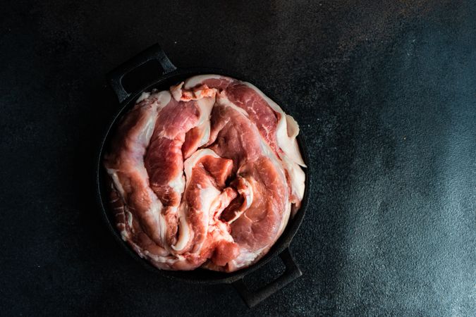 Top view of fresh raw pork in pot to be cooked for dinner