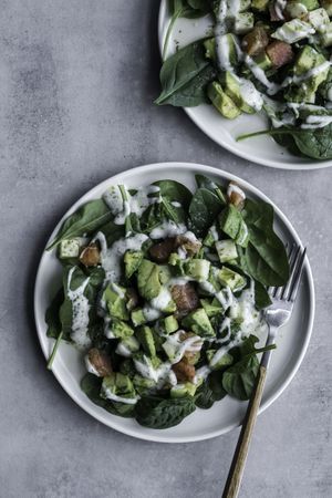 Tasty green salad with salmon on table decorated with citruses
