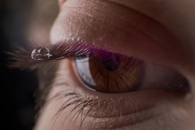 Eye of unrecognizable kid with tear