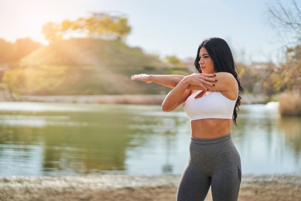 young woman doing stretching exercises while standing