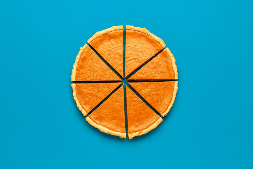 Sliced pumpkin pie top view, on a blue table