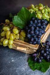 Close up of box fresh green & red grapes with leaves