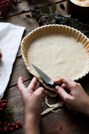 unrecognizable woman making a apple pie on a wooden table