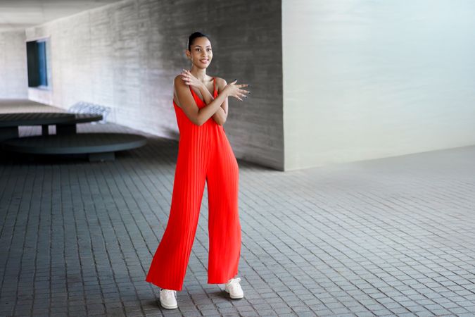 A Stylish Woman in a Red Jumpsuit Posing Confidently Outdoors with an Air of Elegance