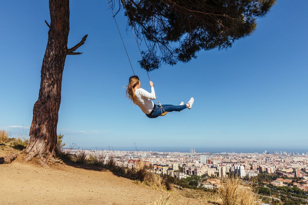Young woman swinging over the city