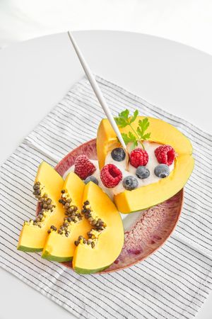 Delicious papaya dessert with berries on table