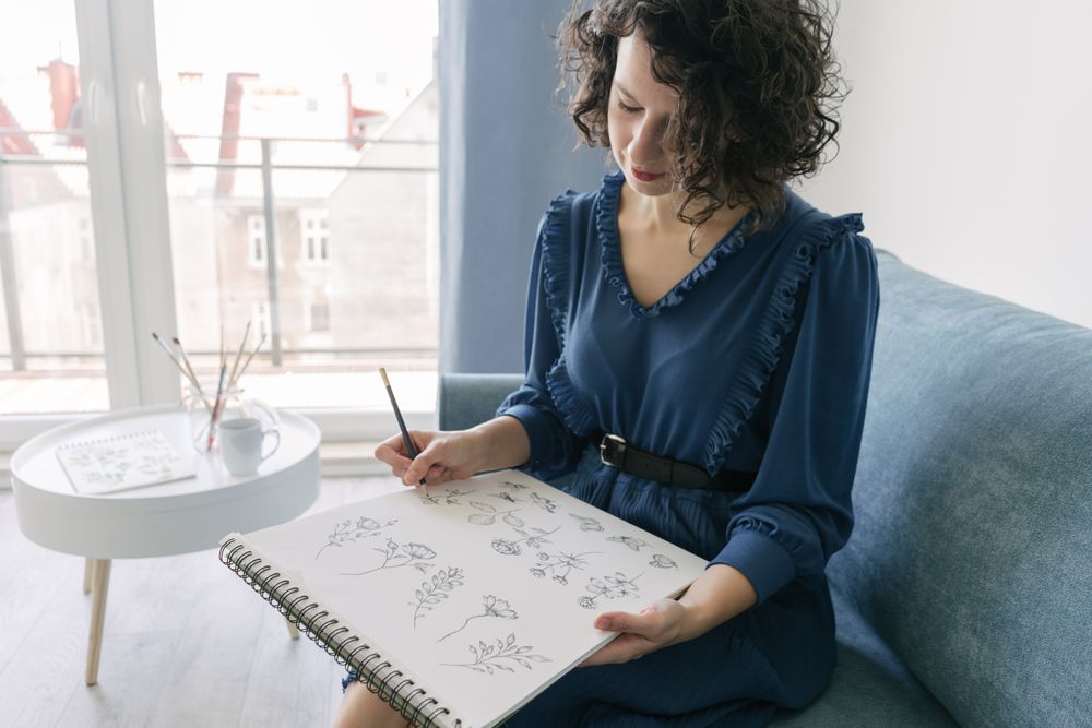 Woman artist drawing at sofa