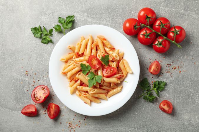 Composition with plate of tasty pasta on gray background, top view