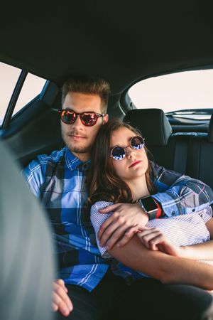Young couple resting in the backseat of the car
