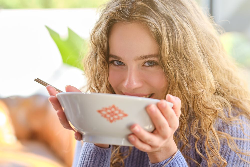 Positive woman with bowl of soup