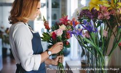 Woman working at flower shop making bouquet bDBOJ5