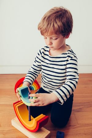 Boy playing with wooden construction pieces