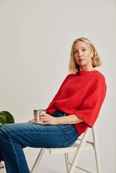 Woman in red sweater sitting on a chair in studio 5wZLy0