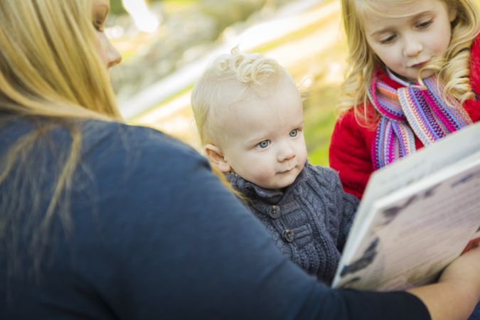 Mother Reading a Book to Her Two Adorable Blonde Children.