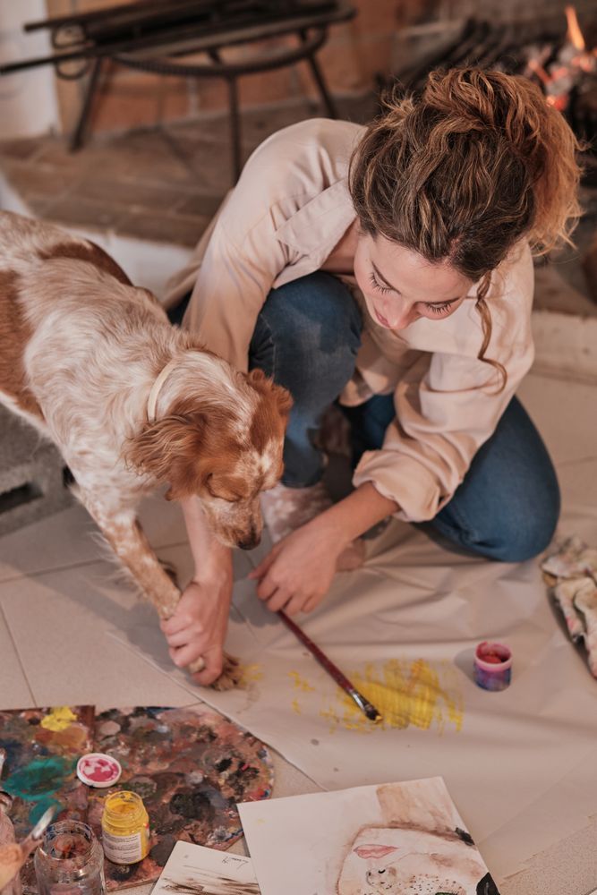 Young woman drawing with dog