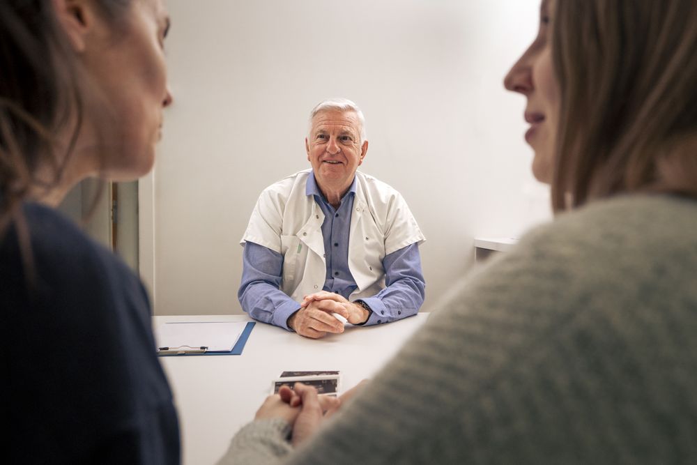 Mature doctor having a consultation with a couple in his office.
