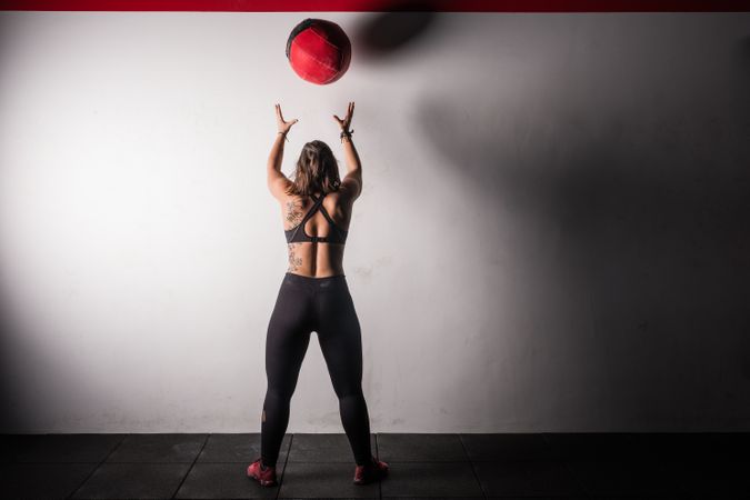 Woman lifting medicine ball in gym