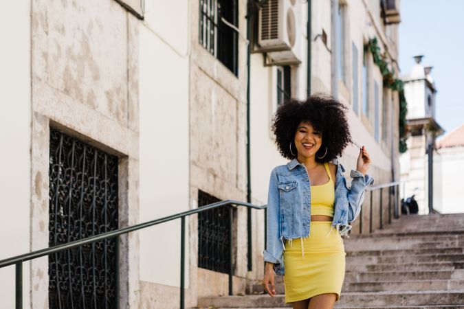 Stylish female standing on stairs with railing outdoors