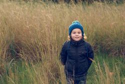 Positive boy standing near grass