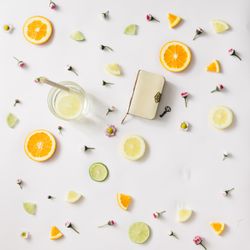 Colorful pattern made of orange, lemon, lime and flowers with lemonade and vintage book with key