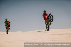 Dirt bike riders doing wheelie on sand dunes 5onOg0