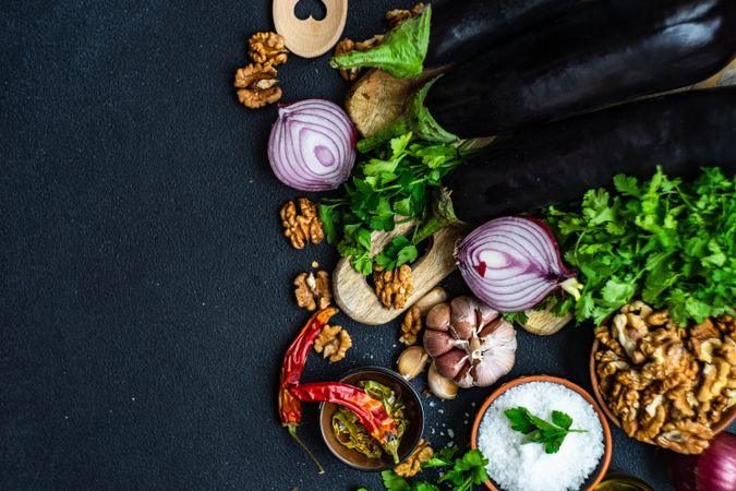 Ingredients for cooking eggplant with walnut dish on rustic background with copy space