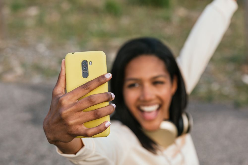 Woman on longboard taking selfie on smartphone