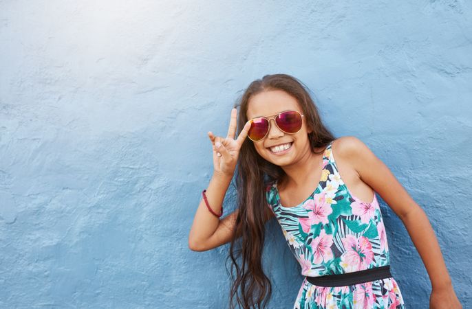 Portrait of cute little girl with sunglasses gesturing peace
