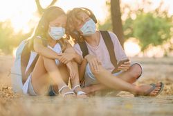 Children in masks listening to music together